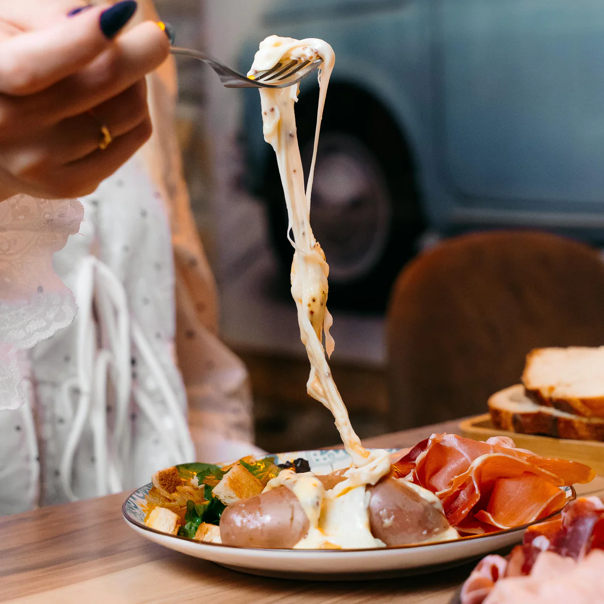 Fils de fromage fondu étirés à la fourchette au-dessus de l'assiette