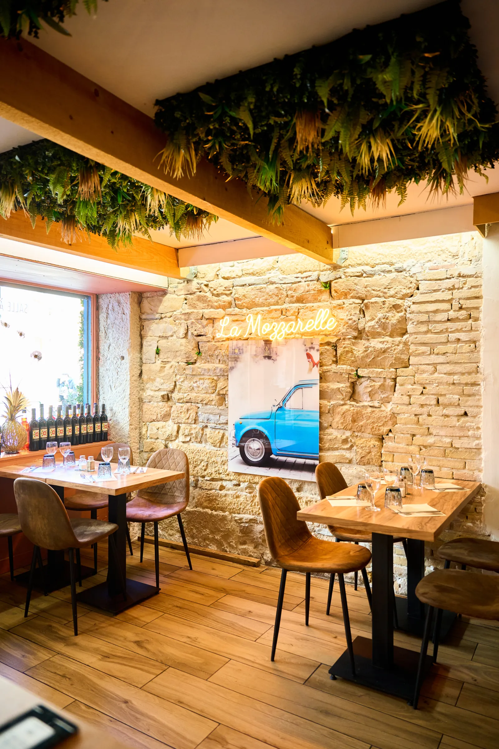 Salle en pierres dorées avec néon La Mozzarelle, restaurant italien Lyon 2